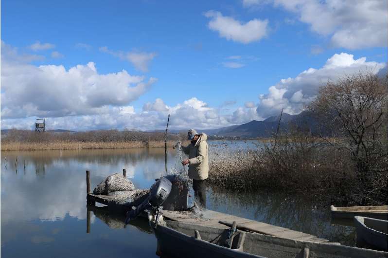 A fisherman prepares a net at the Vain Lagoon -- home to 196 species of migratory birds that pass through each year in search of food and sun