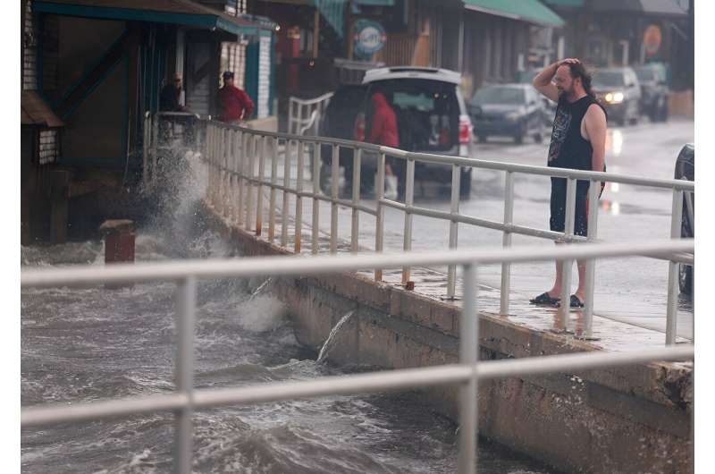 A rain-soaked man in Cedar Key, Florida observes waves kicked up by the winds of Tropical Storm Debby, which is strengthening as it moves through the Gulf of Mexico on August 04, 2024. A rain-soaked man in Cedar Key, Florida observes waves kicked up by the winds of Tropical Storm Debby, which is strengthening as it moves through the Gulf of Mexico on August 04, 2024